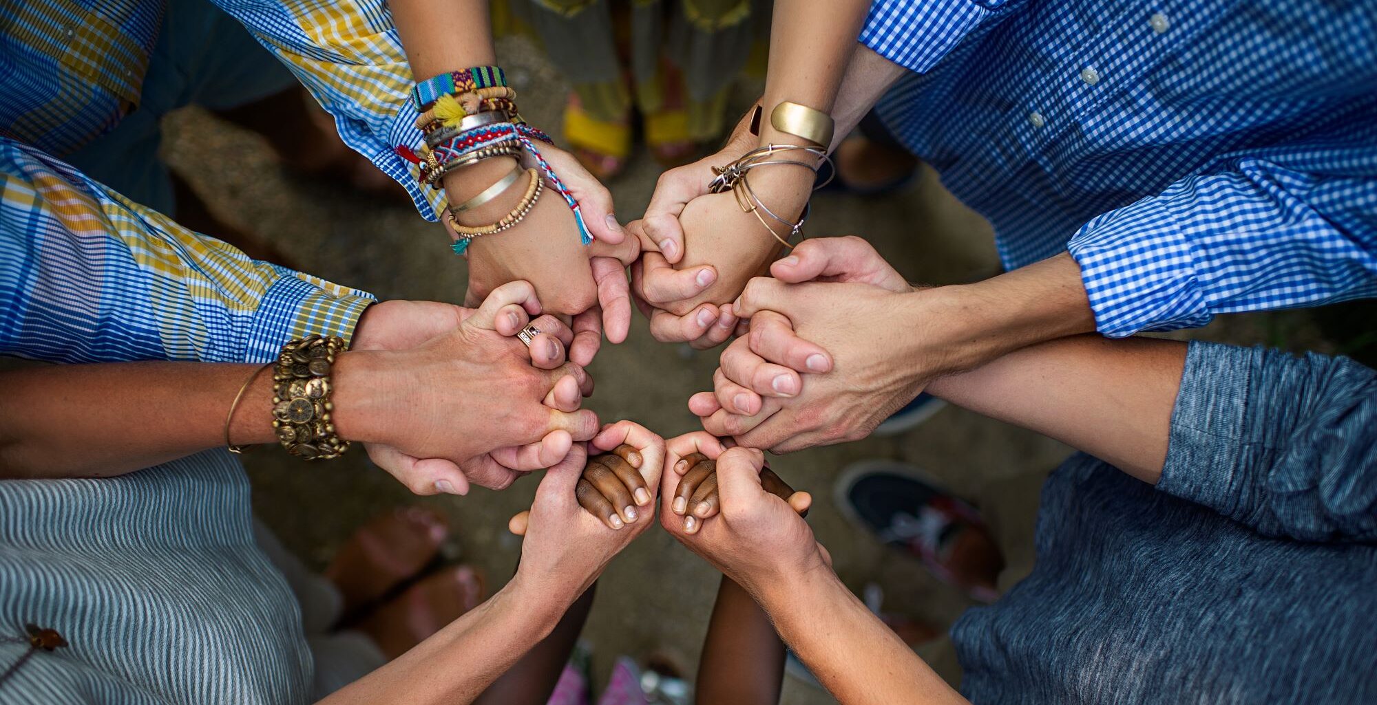 a group of people hold hands in a circle