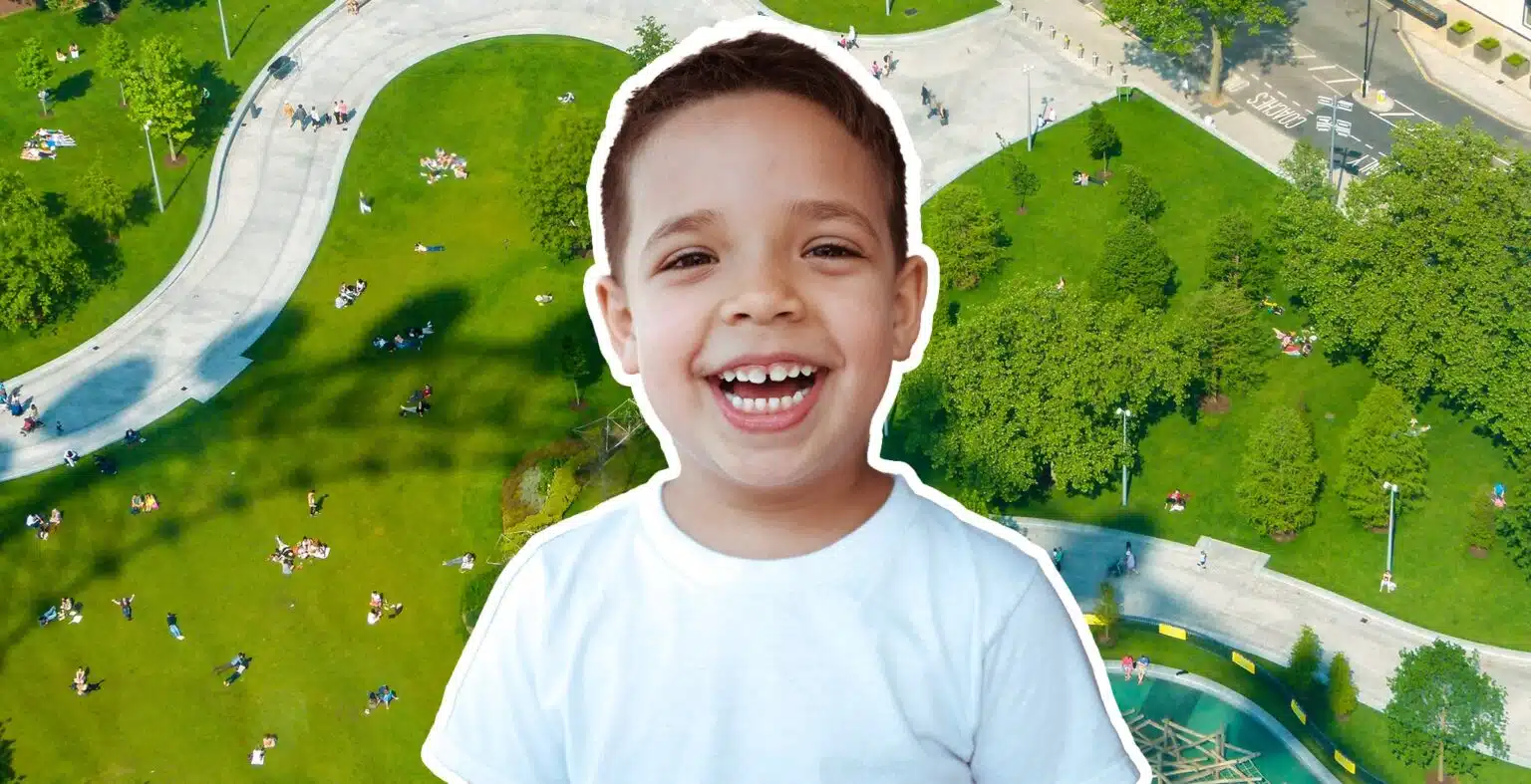 little boy laughing with a park in the background