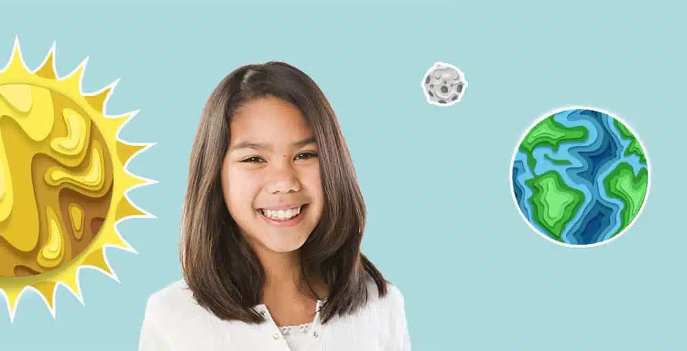 Little girl smiles at camera with solar system in background on light blue background